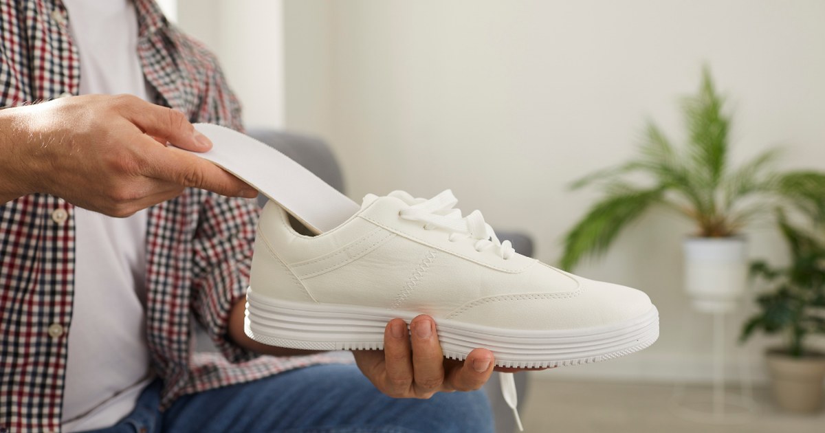 Persona revisando el desgaste de la suela de su zapatilla